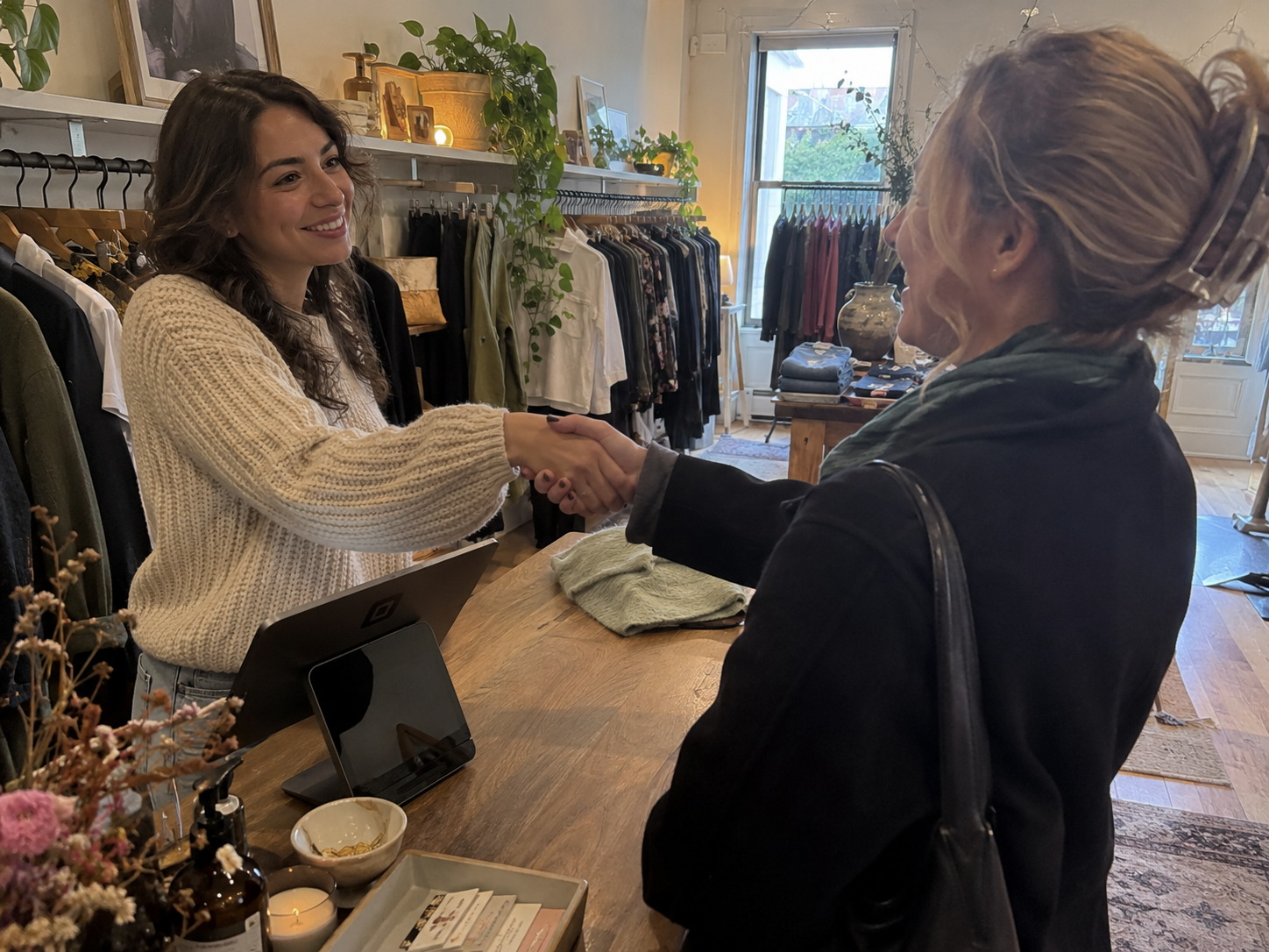 A StyleUAI partner shaking hands with a boutique owner at the store counter